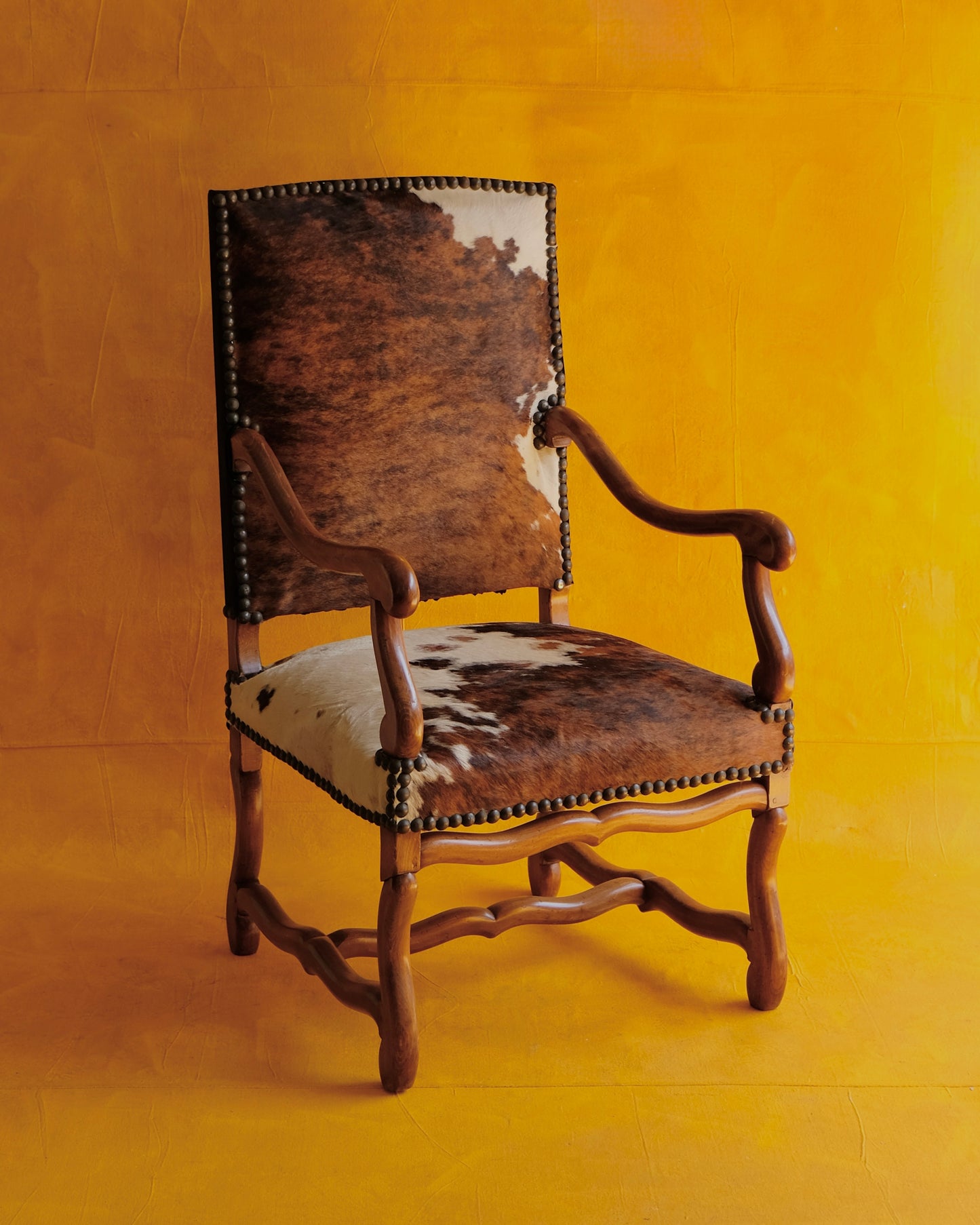 PAIR OF SPANISH WALNUT & COW HIDE ARMCHAIRS