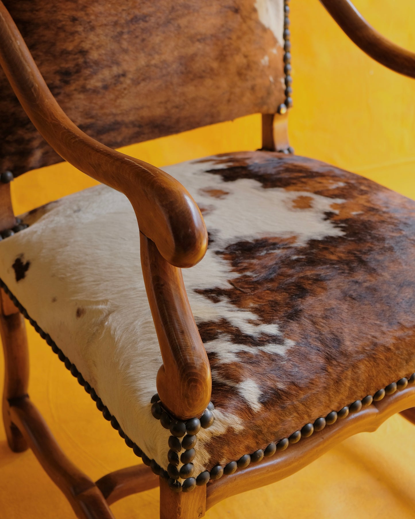 PAIR OF SPANISH WALNUT & COW HIDE ARMCHAIRS