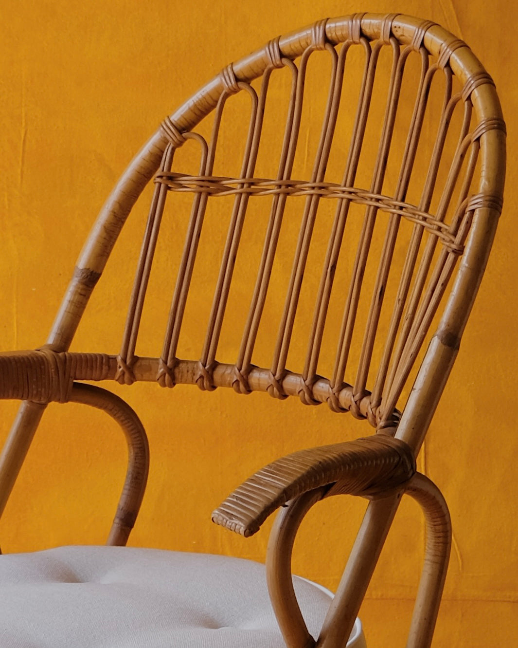 PAIR OF CANE ARM CHAIRS w. CONTRAST CUSHIONS
