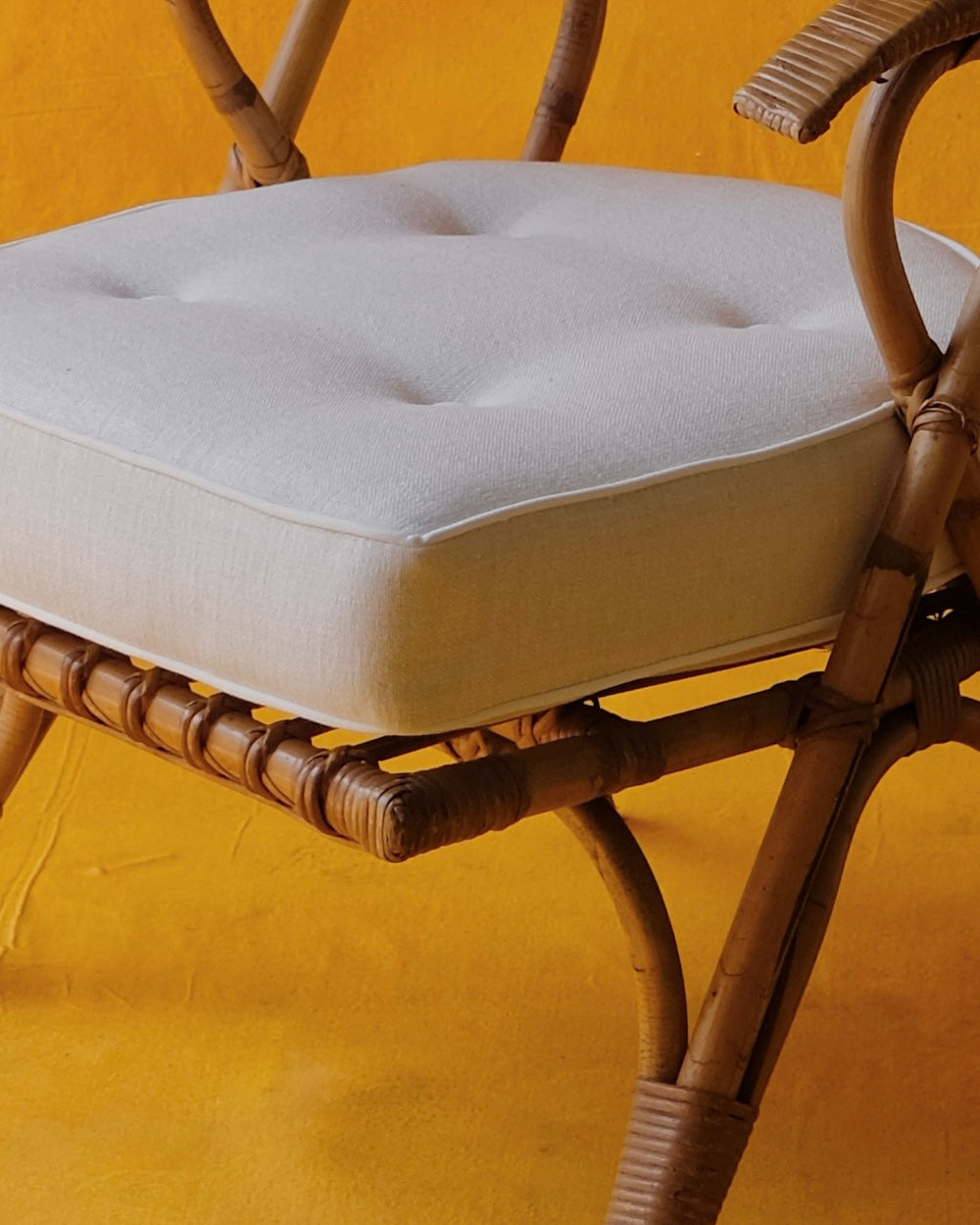 PAIR OF CANE ARM CHAIRS w. CONTRAST CUSHIONS